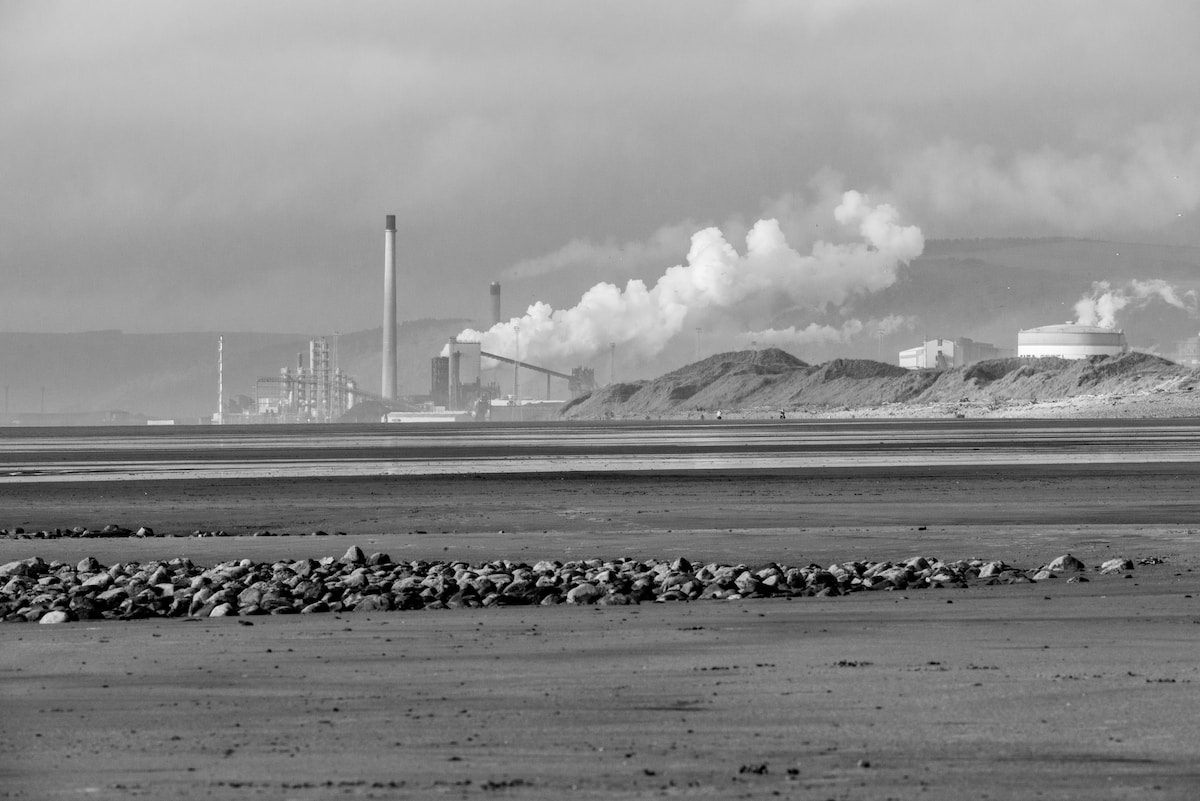 a black and white photo of smoke stacks in the distance